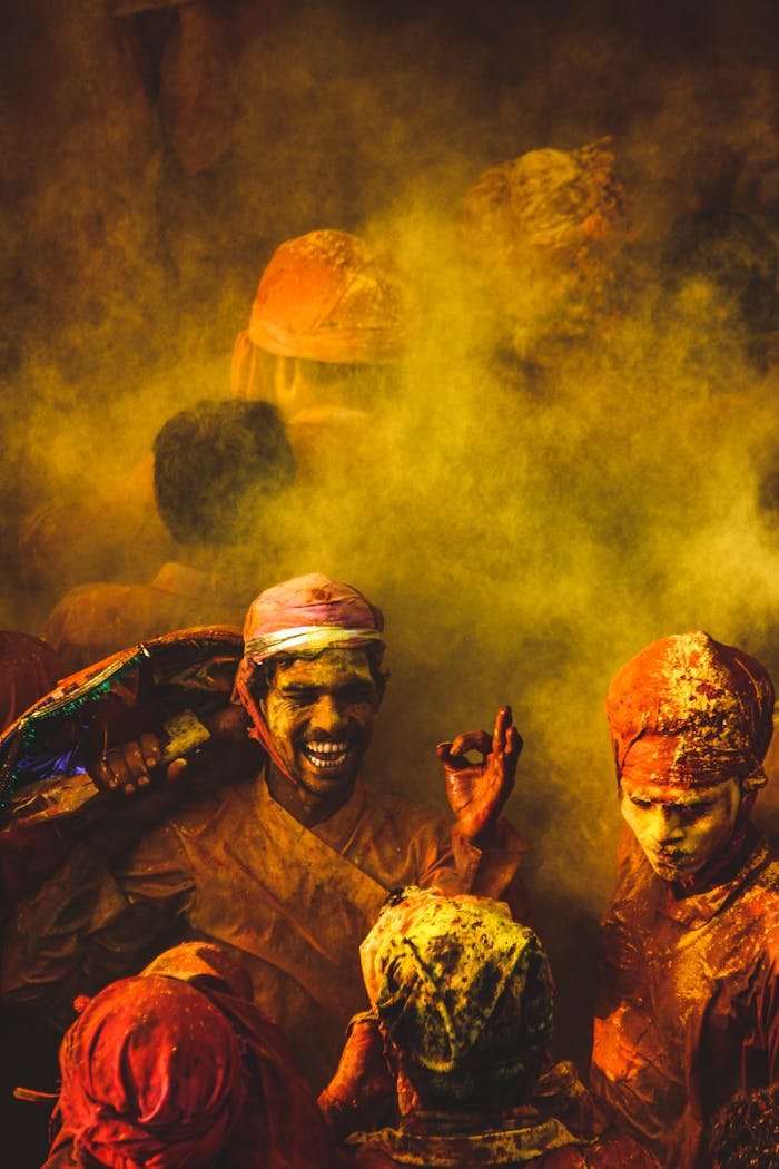 Joyful group celebrating Holi with vibrant colors and traditional attire in India.